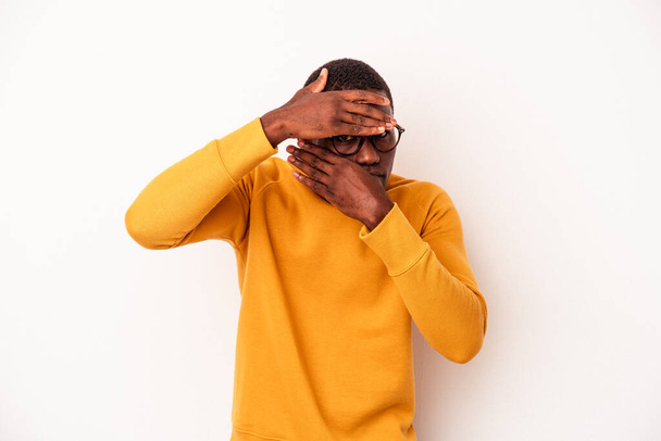 Young African American man isolated on white background blink at the camera through fingers, embarrassed covering face. - Foto, Imagem