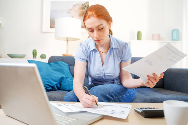 Woman accounting and holding utility bill and bank statements - Foto, afbeelding