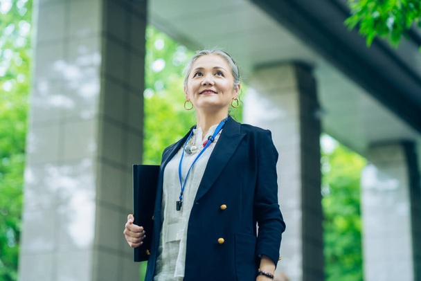 Asian gray-haired business woman standing outdoors - Fotoğraf, Görsel