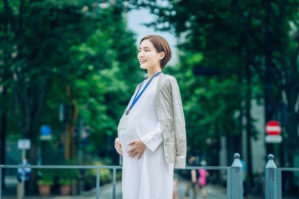 Pregnant business woman with white clothes standing outdoors - Photo, image