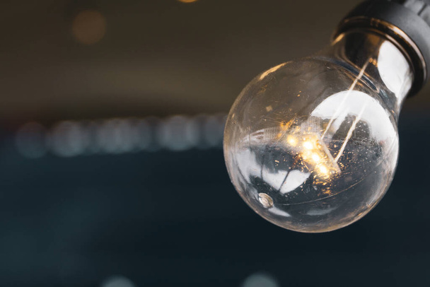 Light bulb in the foreground with copy space to the left of the photo. - 写真・画像