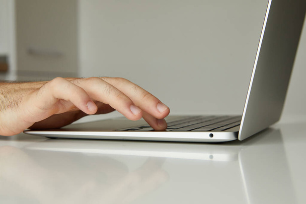 чоловік працює на ноутбуці, його руки крупним планом
 - Фото, зображення