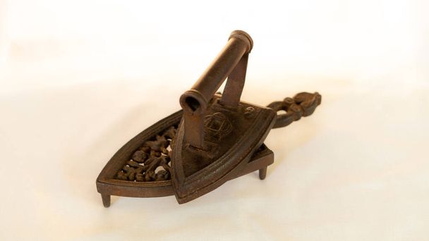 antique iron with wooden handle on light bottom - Fotoğraf, Görsel