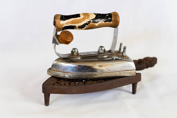 antique iron with wooden handle on light bottom - Fotografie, Obrázek