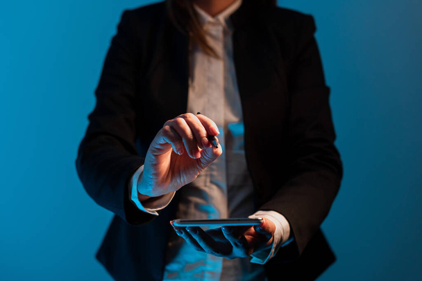 Stojící podnikatelka držící mobilní telefon s důležitými zprávami. - Fotografie, Obrázek