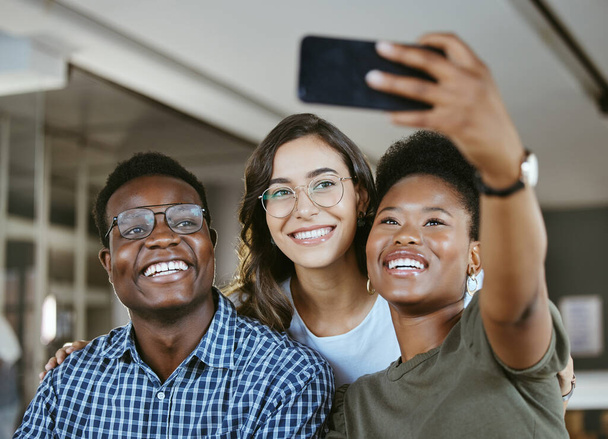 Groupe de jeunes gens d'affaires joyeux prenant un selfie ensemble au travail. Heureuse femme d'affaires afro-américaine prenant une photo avec ses collègues sur son téléphone dans un bureau. - Photo, image