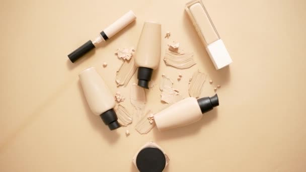 Flessen make-up foundation en samples op beige achtergrond. Vlakke lay, bovenaanzicht - Video