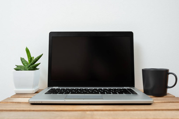 Lap Top With Important Information On Table With Plant And Cup Of Coffee. - 写真・画像