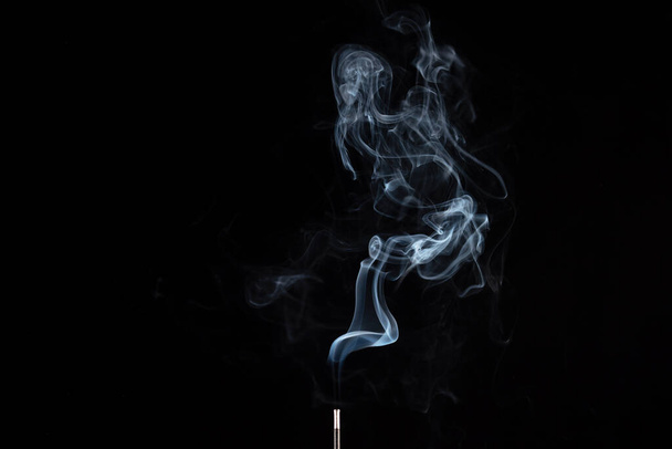 Räucherstäbchen mit Rauch vor schwarzem Hintergrund - Foto, Bild