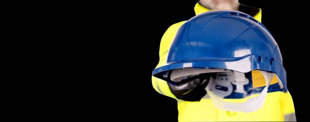 Un constructor en casco amarillo, de color amarillo brillante reflectante de alta visibilidad fleeceand guantes de seguridad fondo blanco con espacio para el texto que da gafas de seguridad. Siempre use el PPE correcto en el concepto de póster de seguridad del sitio de construcción - Foto, Imagen
