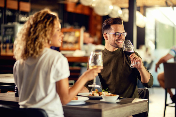 Happy couple drinking wine while eating lunch in a restaurant.  - Photo, Image