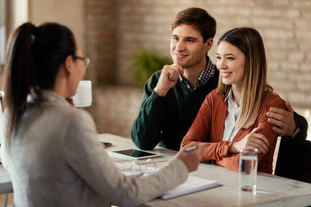 Happy couple talking with their insurance agent on a meeting in the office.  - 写真・画像