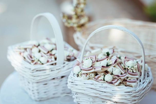 Close-up of white wicker basket with decoration for guests at wedding reception. - Fotó, kép