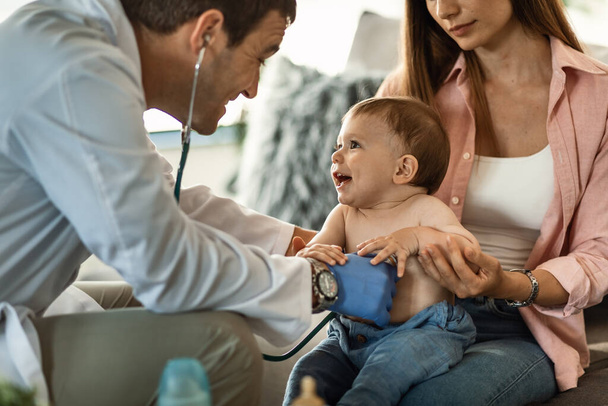 Счастливый мальчик веселится, пока доктор слушает его сердцебиение стетоскопом. - Фото, изображение