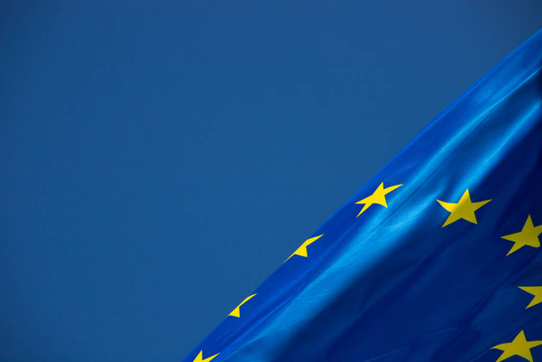 Европейский флаг на ветру с прекрасным голубым небом на заднем плане. Место для размещения текста - Фото, изображение