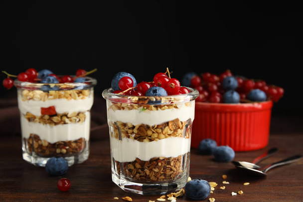 Delicious yogurt parfait with fresh berries on wooden table - Foto, Bild