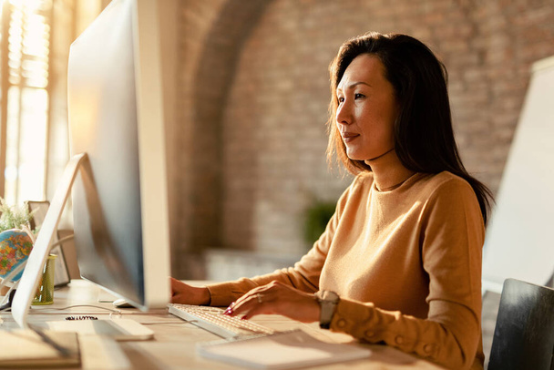 Asian female entrepreneur using desktop PC while working in the office.  - Φωτογραφία, εικόνα