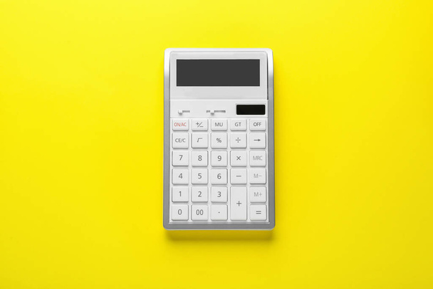 White calculator on yellow background, top view - Φωτογραφία, εικόνα