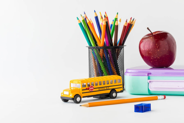 Vissza az iskolai felszereléshez, ceruzával, uzsonnás dobozzal és almával, balra másoló hellyel. - Fotó, kép