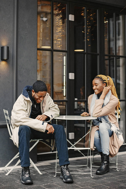 Two young people sitting outside. African couple enjoying the time spending with each other. - Valokuva, kuva