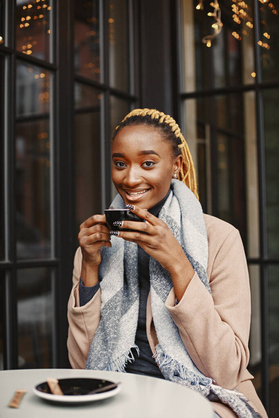 People and leisure concept. Headshot of beautiful African girl. Woman holding cup of hot drink. - Valokuva, kuva