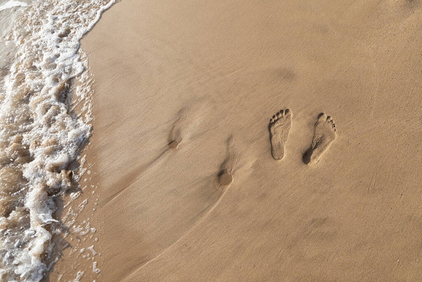 Two sets of footprints in the sand on a walk in Maui Hawaii. - Фото, изображение