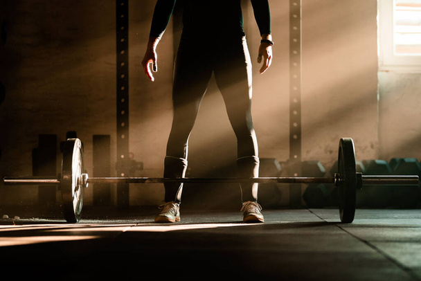 Unrecognizable sportsman having weightlifting training in a gym. Copy space. - Фото, зображення
