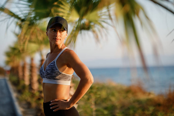 Portrait of female athlete standing outdoors and looking away in the morning.  - Foto, Imagem