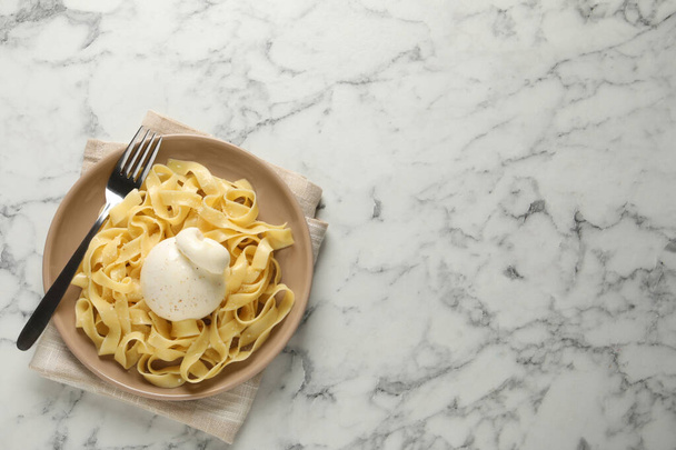 Herkullista pastaa burrata-juustolla valkoisella marmoripöydällä, ylhäältä. Tekstitila - Valokuva, kuva