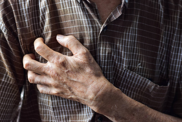 Asiatischer älterer Mann leidet an Schmerzen in der rechten Brust. Brustschmerzen können durch Herzinfarkt, Herzinfarkt oder Ischämie, Myokarditis, Lungenentzündung, Stress usw. verursacht werden.. - Foto, Bild