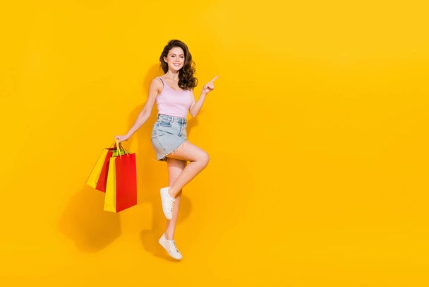 Full size photo of charming attractive lady jump direct finger empty space isolated on yellow color background. - Φωτογραφία, εικόνα