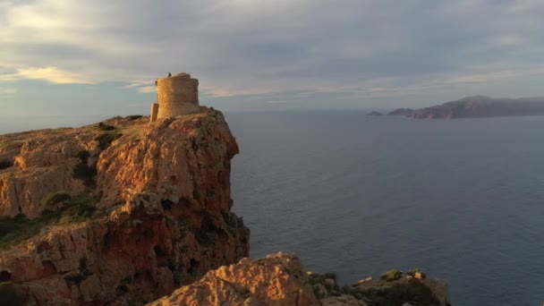 Aerial view of the Capo Rosso Tower in Corsica. Drone view of the Turghiu tower at sunset in France. Mediterranean Sea coastline - Кадры, видео