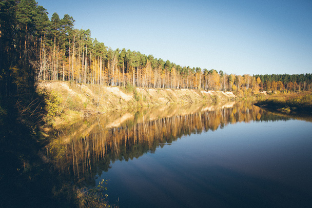scenic autumn colored river in country. Retro grainy film look. - Fotografie, Obrázek