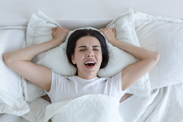 A beautiful woman lies in bed, enjoys an orgasm, alone at home. - Фото, зображення