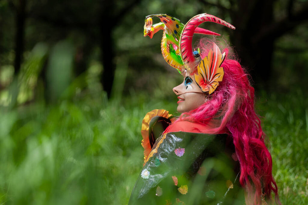 Hispanic woman Bolivian seated in diablada pillarea costume in the middle of the forest vertical shot front view - Foto, immagini