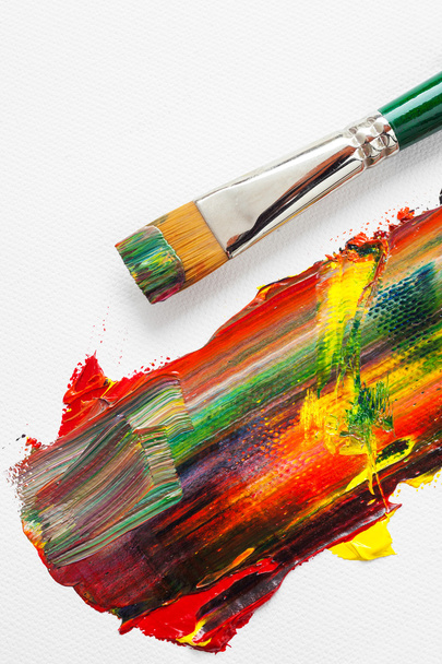 Pinsel und gemischte Regenbogen-Ölfarben auf Leinwand - Foto, Bild
