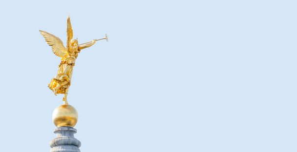 Знамя со старой статуей золотого ангела в качестве воина и защитника на вершине купола в центре Дрездена, Германия, с копировальным пространством синего неба твердого фона - Фото, изображение