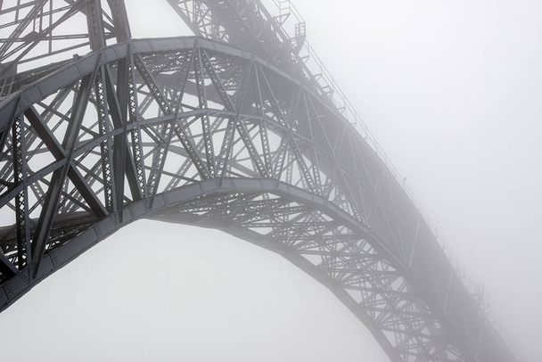 Régi és ikonikus D Maria vashíd ködös Douro folyó felett, Porto, Portugália. - Fotó, kép
