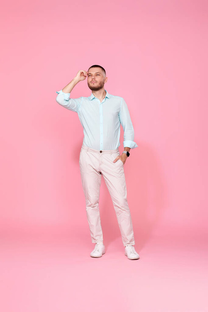 positive dreamy thoughtful young man thinking isolated on pink background. Full length - Foto, Imagem