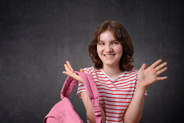 Muotokuva onnellinen koulutyttö hymyilee ja pitää reppu, katsot kameraa - Valokuva, kuva