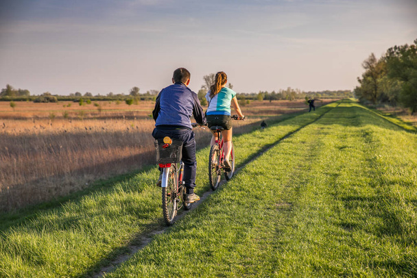 Young people on a bicycle during a bicycle tour, embankment  over the Vistula river bank near Karczew and Otwock - Fotoğraf, Görsel