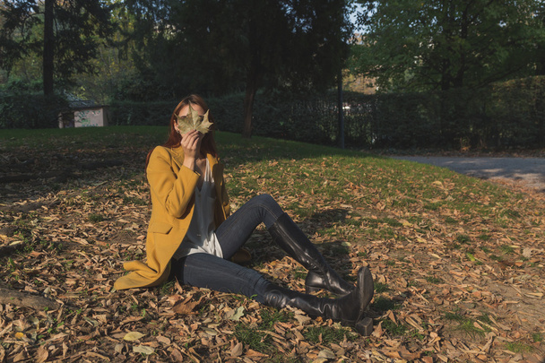 Redhead girl posing in a city park - Φωτογραφία, εικόνα