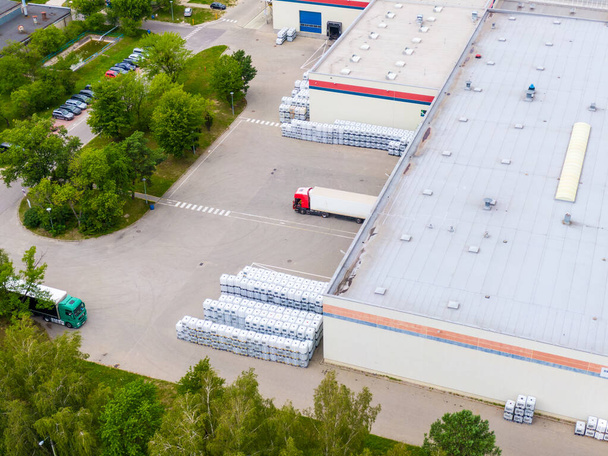 Luchtfoto van goederenmagazijn. Logistiek centrum levering in industriële stad zone van bovenaf. Luchtfoto van vrachtwagens laden in logistiek centrum - Foto, afbeelding