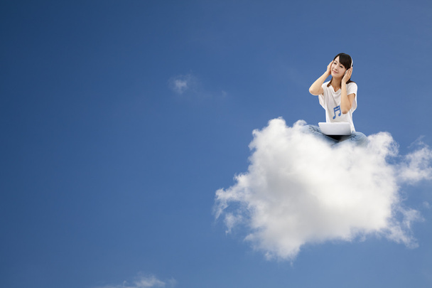 Nainen kuuntelee musiikkia ja istuu pilvellä
 - Valokuva, kuva