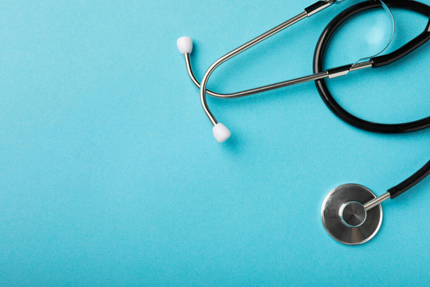 Stethoscope on a blue background, top view. Space for text.Cardiology concept - Photo, image