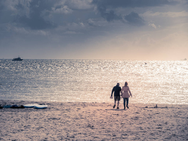 La Rochelle, France, July 2022. A city beach in La Rochelle, France, a walking couple in love at sunset - Photo, Image