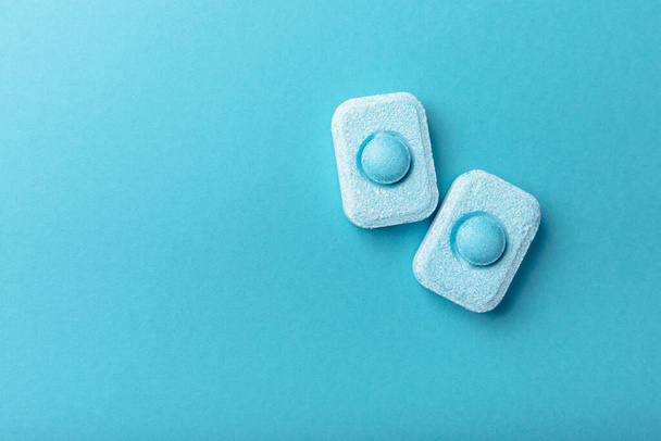 Water softener tablets on a blue background, flat lay. Space for text.Capsules for washing machines and dishwashers that prevent limescale. Place to copy. - Фото, зображення