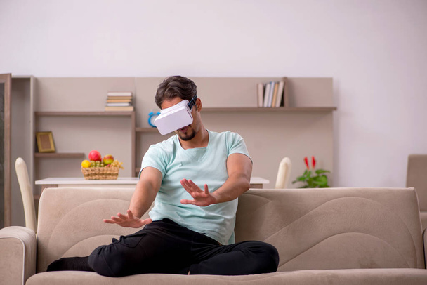 Young man wearing virtual glasses at home - Φωτογραφία, εικόνα