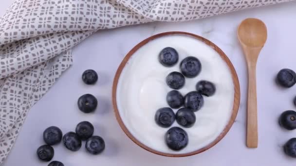 A portion of blueberry yogurt in a wooden bowl ready to be served. Healthy food for dieting concept. Dolly shot 4k - Video