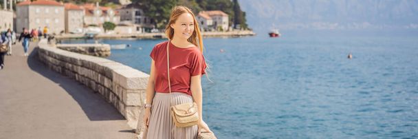 BANNER, LONG FORMAT Woman tourist enjoying Colorful street in Old town of Perast on a sunny day, Montenegro. Travel to Montenegro concept. Scenic panorama view of the historic town of Perast at famous - Photo, image